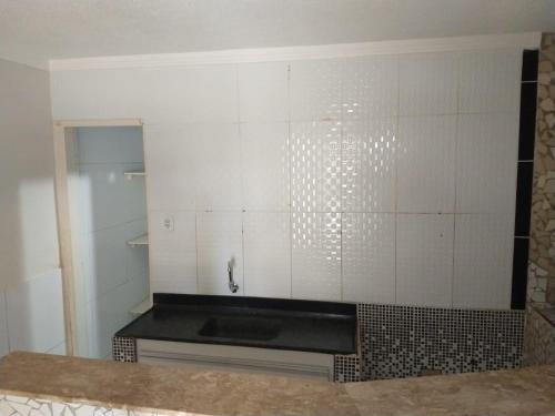 a kitchen with white walls and a black counter top at Village Galés Maragogi in Maragogi