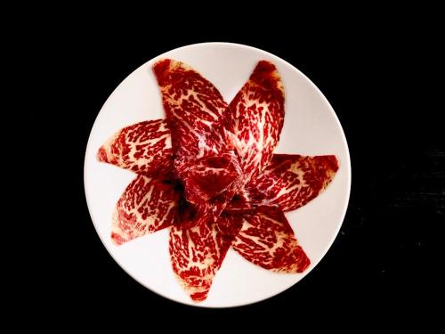 a white plate with a red flower on it at Hotel Real Colegiata San Isidoro in León