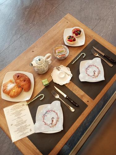 Una mesa con platos de comida encima. en Maison Bionaz Luxury Ski & Sport, en Aosta