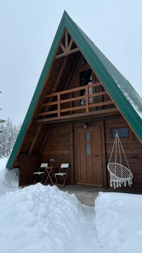 a log cabin with a porch in the snow at Mountain Houses Emilija in Žabljak