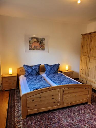 a bedroom with a large wooden bed with blue pillows at Gästewohnung " Am Harsdorf " in Magdeburg