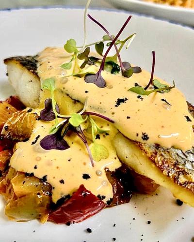 a white plate of food with cheese and vegetables at Hotel Real Colegiata San Isidoro in León