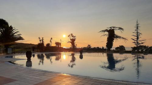 - une piscine avec vue sur le coucher du soleil en arrière-plan dans l'établissement Atlantic Selection - Domaine de Bordaberry - Avec piscine et vue océan, à Urrugne