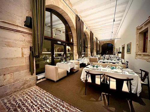 Un comedor con mesas y sillas en un restaurante. en Hotel Real Colegiata San Isidoro, en León