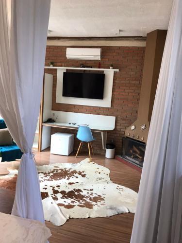 a living room with a fireplace and a tv and a couch at Pousada Reserva Penedo in Penedo