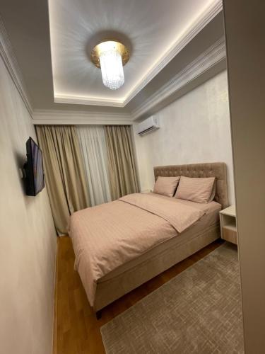 ein kleines Schlafzimmer mit einem Bett mit einer Decke in der Unterkunft Hills Apartments in Podgorica
