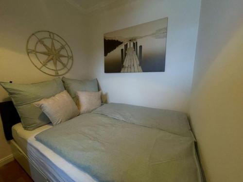 1 cama en un dormitorio con una foto en la pared en Sandliebe en Grömitz