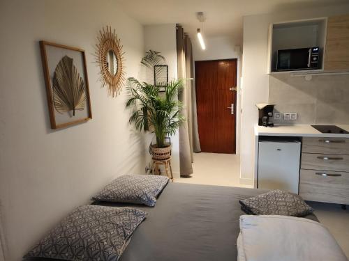 マンドリュー・ラ・ナプールにあるSTUDIO Cannes Marinaのベッドルーム(ベッド1台、鉢植えの植物付)