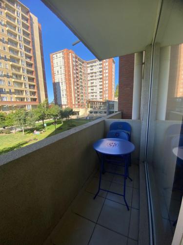 a balcony with two blue chairs and a table at Parque urbano in Concepción