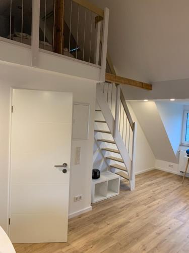 a room with a staircase and a white door at City-Apartment Düsseldorf in Düsseldorf