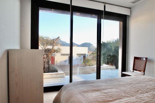 サン・ホセにあるCasa Palomaのベッドルーム(大きなガラス窓、ベッド付)
