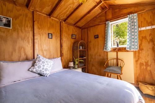 a bedroom with a bed and a window at Ao Marama Retreat in Collingwood