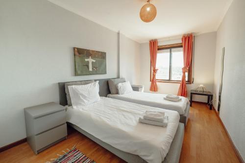 sypialnia z 2 łóżkami i oknem w obiekcie Matosinhos Seaside Apartment by Vacationy w mieście Matosinhos