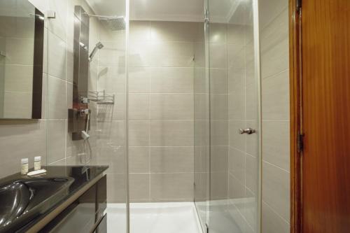 W łazience znajduje się prysznic i umywalka. w obiekcie Matosinhos Seaside Apartment by Vacationy w mieście Matosinhos