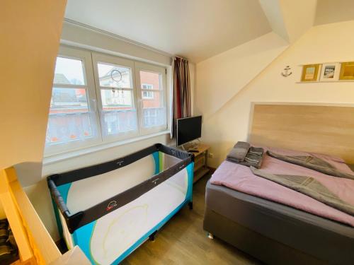 a small bedroom with a bed and a window at Ein kleines Haus in Fehmarn