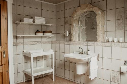 a white bathroom with a sink and a mirror at Ferienhaus Anno 1810 in Wadern