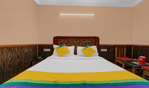 a bedroom with a large bed with colorful pillows at Itsy Hotels Rain Forest in Ooty