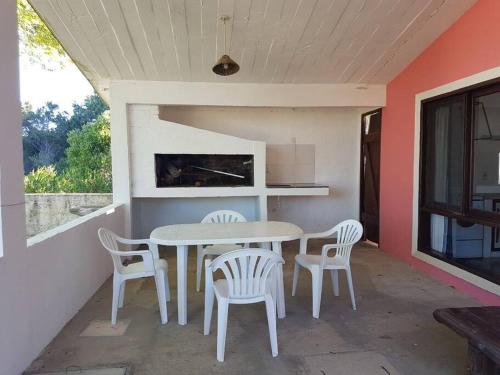 una mesa y sillas en un patio con chimenea en La Rosadita, un escape tranquilo en La Pedrera., en La Pedrera