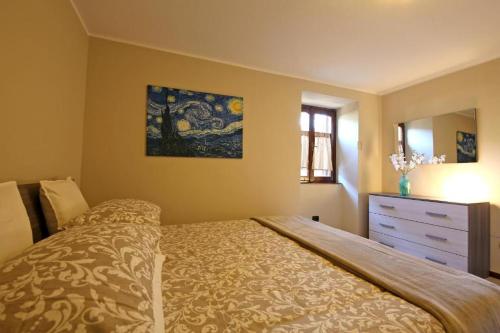 a bedroom with a bed and a dresser and a mirror at Bellagio Apartment San Giovanni in Bellagio