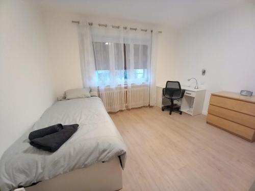 a bedroom with a bed and a desk and a chair at Villa Sainte-Rose 3ch à 5 minutes de la Cité des Loisirs in Amnéville
