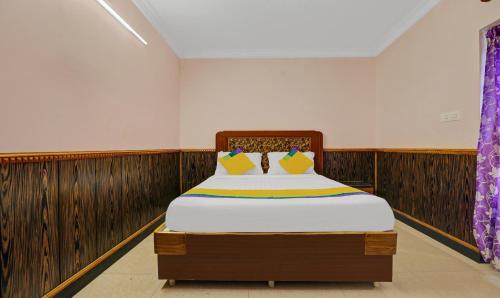 a bed in a room with wood paneling at Itsy Hotels Rain Forest in Ooty