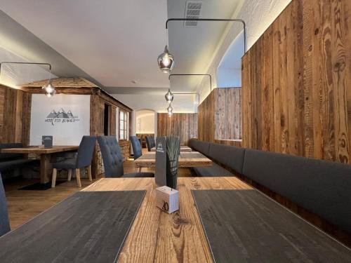 a dining room with wooden walls and a table and chairs at Hotel Rio Bianco in Panchia