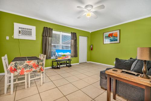 a living room with green walls and a ceiling fan at Old Wooden Bridge Resort & Marina in Big Pine Key