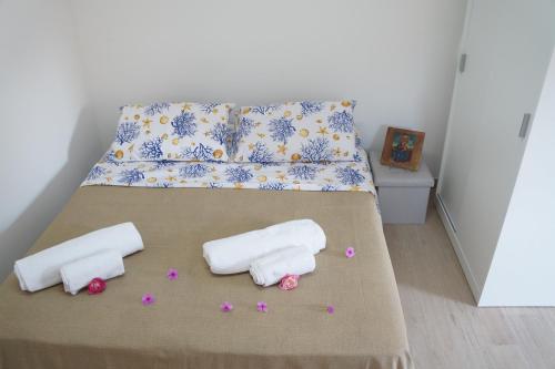 un letto con due asciugamani e fiori sopra di Casa Vacanza da Sara a Custonaci
