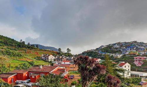 a town on top of a hill with houses at Itsy Hotels Rain Forest in Ooty