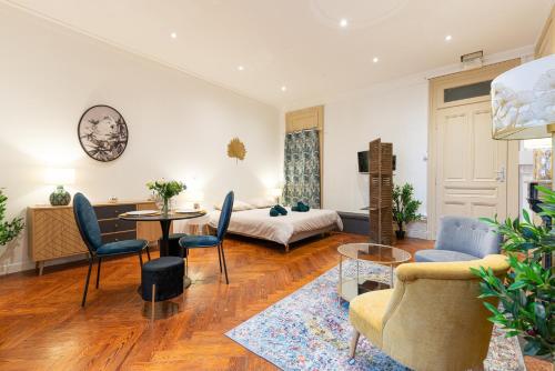 sala de estar con cama, mesa y sillas en Ancien Palace Bernascon vue sur lac Classé 3 étoiles, en Aix-les-Bains