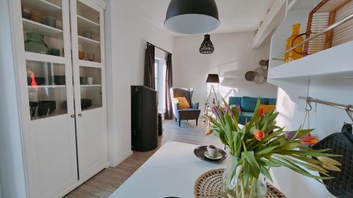 uma sala de estar com uma mesa com um vaso de flores em Ferienhaus im Wesenitztal em Stolpen