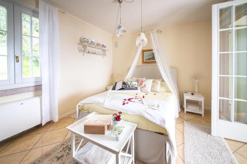 ein Schlafzimmer mit einem weißen Bett und einem Tisch in der Unterkunft Le Gemme Suite B&B in Verona