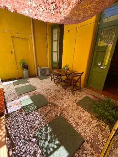 eine Terrasse mit einem Tisch und ein gelbes Gebäude in der Unterkunft Casa Calma in Colonia del Sacramento