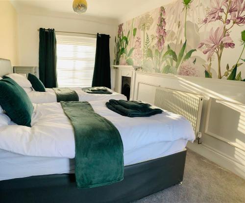 um quarto com 3 camas com verde e branco em White Horses Anglesey em Newborough