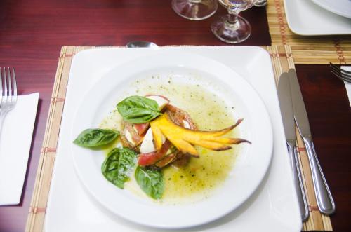 a white plate with a dish of food on a table at Hotel Arenas en Punta Leona in Jacó