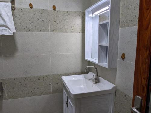 a bathroom with a white sink and a mirror at Bliss haven gardens two bedroom apartment in Nairobi