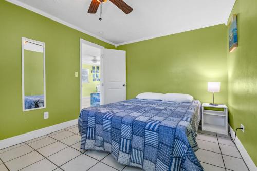 a bedroom with a bed and green walls at Old Wooden Bridge Resort & Marina in Big Pine Key