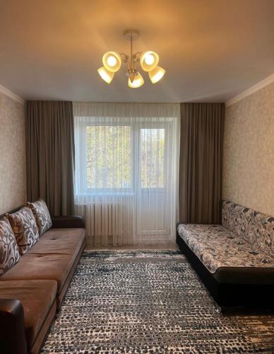 a living room with a couch and a window at Аэропорт Алматы in (( Turksib ))