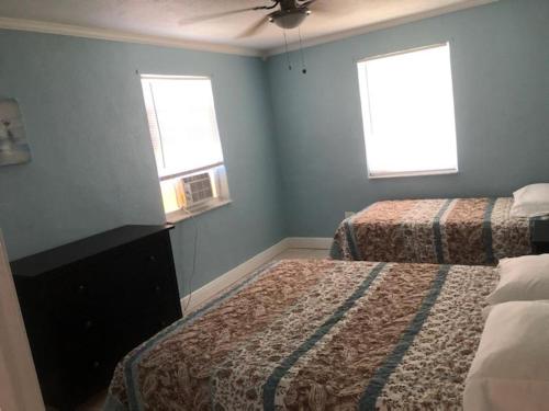 a bedroom with two beds and two windows at Old Wooden Bridge Resort & Marina in Big Pine Key