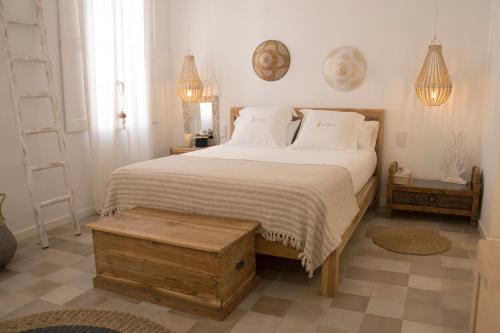 Un dormitorio con una cama grande con sábanas blancas y una mesa. en Infinito Hotel Boutique - Adults Only en Ciutadella