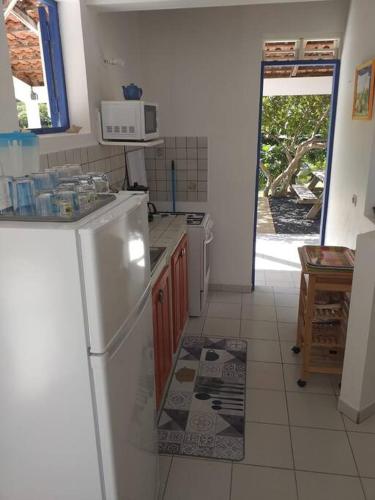 a kitchen with a white refrigerator and a microwave at Villa Campêche Marine in Le Marin