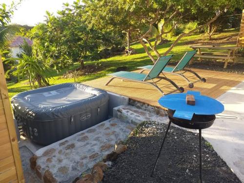 a patio with a hot tub and a table and chairs at Villa Campêche Marine in Le Marin