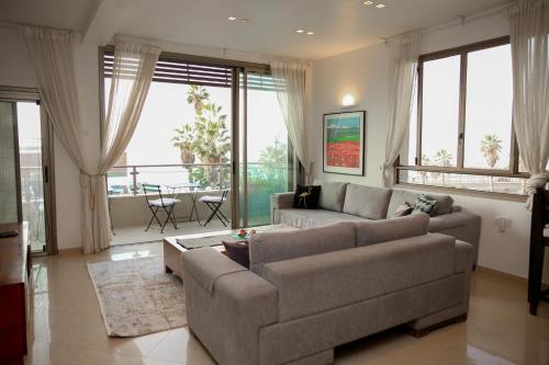 een woonkamer met een bank en een tafel bij Sea View Apartment Prime Location On The Beach in Tel Aviv