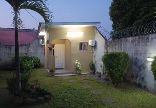 een huis met een witte deur en een hek bij Chambre américaine à Angondjé in Libreville