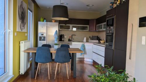 kuchnia z drewnianym stołem i niebieskimi krzesłami w obiekcie Luxurious villa-apartment with spacious terrace w Pradze