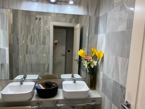 a bathroom with two sinks and a mirror at Duplex de lujo en la playa , jacuzzy, piscina, chimenea y padel in Benalmádena