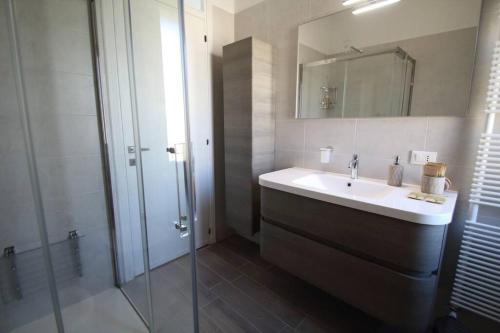 a bathroom with a sink and a glass shower at Casa Ol Gàl in Bergamo