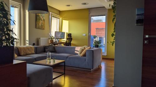 a living room with a blue couch and a table at Luxurious villa-apartment with spacious terrace in Prague