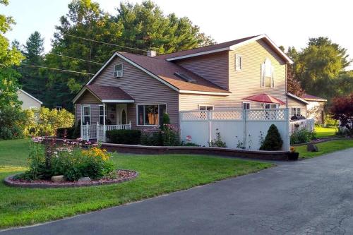 a house with a white fence in the yard at Adirondack Valley House - Close to Saratoga Track in Saratoga Springs