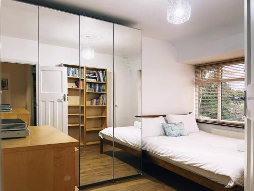 a bedroom with two beds and a glass wall at Jenny's Place in Hendon